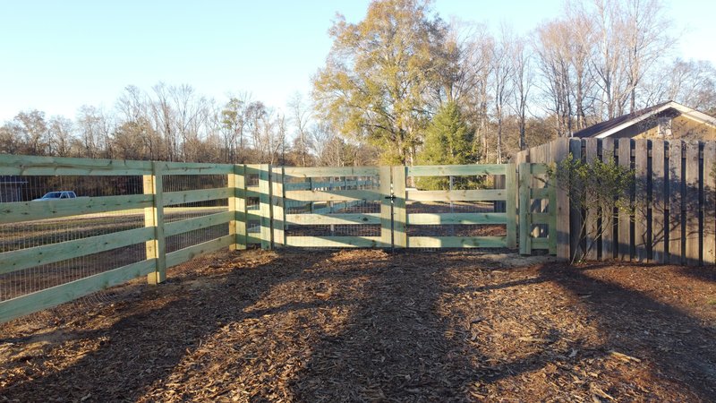 Wood post-and-board ranch fence with gate